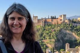 Lynn Kistler smiles in front of a medieval town. 