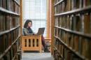 UNH online MBA student studying in the library